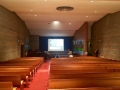 The auditorium has good acoustics, with original Saarinen chairs and desks on the stage. The original bentwood benches are child-sized, with smaller scale benches towards the front and larger ones in the back.