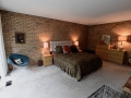 Exposed brick and wood walls (off camera) make for a very comfortable and cozy master suite